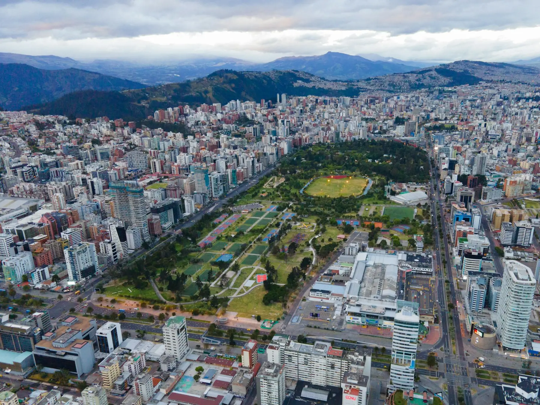 Vista aérea del parque La Carolina en el norte de Quito, con los edificios de la Amazonas y las montañas al fondo